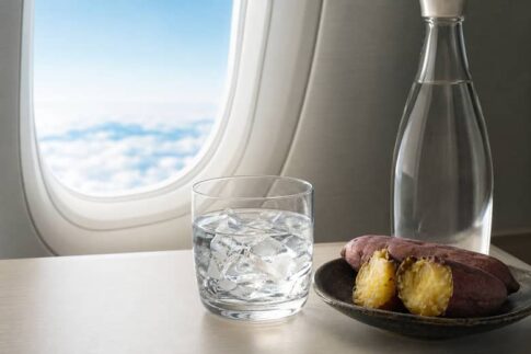 空の旅を思わせる窓辺の焼酎グラスと芋